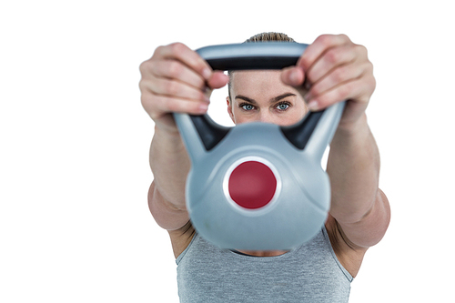 Serious muscular woman lifting kettlebell on white background