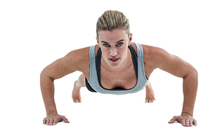 Muscular woman doing push-ups on white background