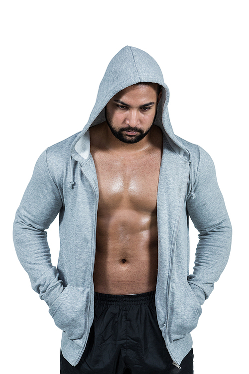 Muscular man in hooded jumper on white background