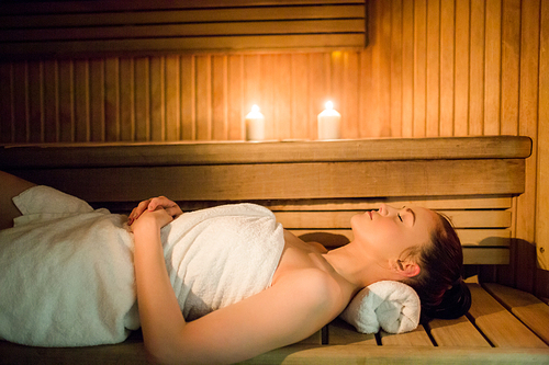 Pretty woman relaxing in the sauna in the spa
