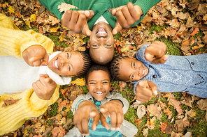 Young family doing a head circles and pointing the camera on an autumns day