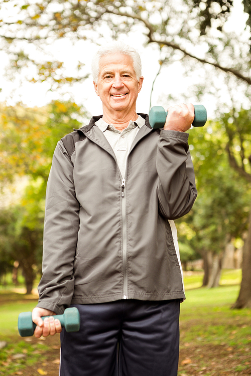 Senior man working out in park on an autumns day