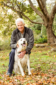 Senior man with his dog in park on an autumns day