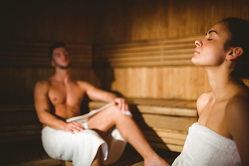 Happy couple enjoying the sauna together at the spa