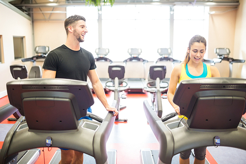 Man and woman using treadmills at the gym