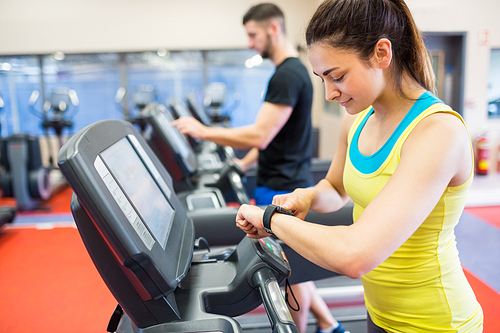 Couple using treadmills together at the gym