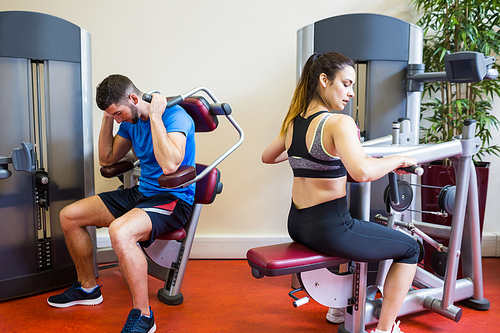 Fit man and woman working out at the gym