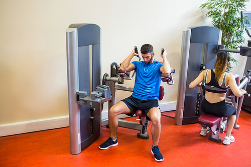 Fit man and woman working out at the gym