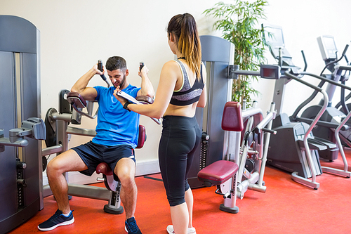 Fit man with trainer working out at the gym