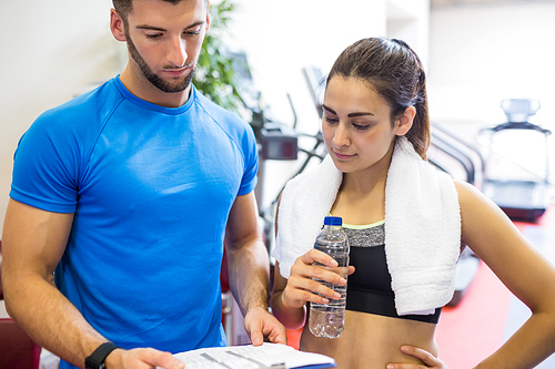 Trainer and athlete discussing workout plan at the gym