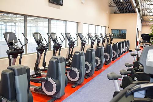 Collection of exercise bikes in a row at the gym