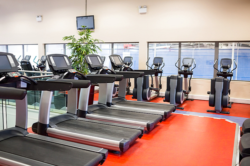 Row of treadmills and exercise bikes at the gym