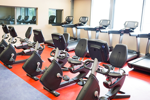 Row of treadmills and exercise bikes at the gym