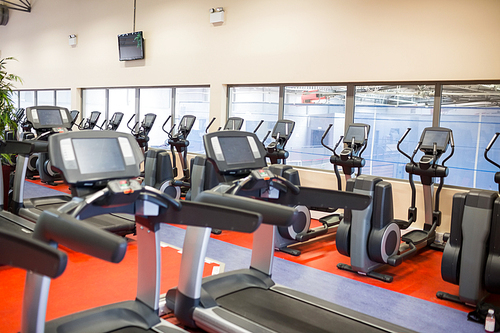 Row of treadmills and exercise bikes at the gym