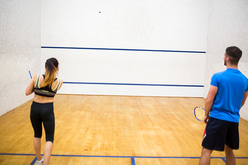 Couple play some squash together in the squash court