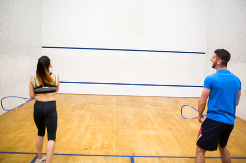 Couple play some squash together in the squash court