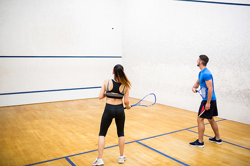 Couple play some squash together in the squash court