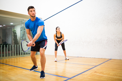 Couple play some squash together in the squash court