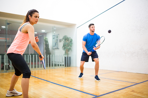 Couple play some squash together in the squash court