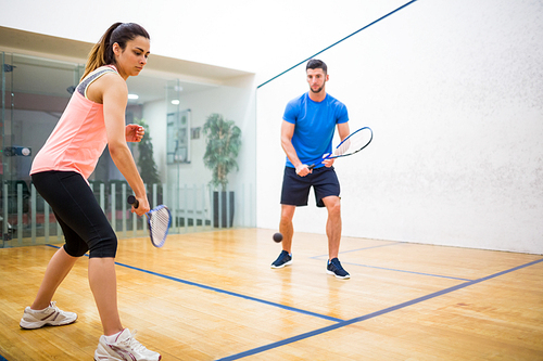 Couple play some squash together in the squash court