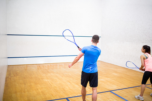 Couple play some squash together in the squash court