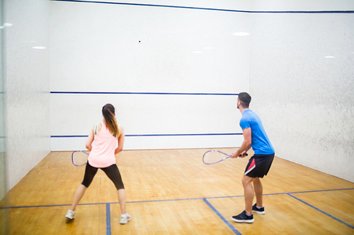 Couple play some squash together in the squash court