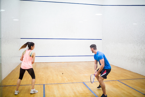 Couple play some squash together in the squash court