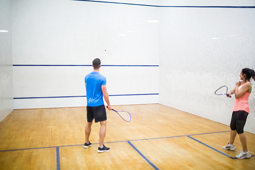 Couple play some squash together in the squash court