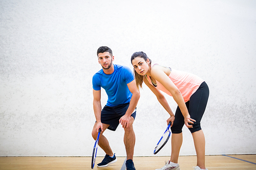 Couple tired after a squash game in the squash court