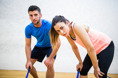 Couple tired after a squash game in the squash court