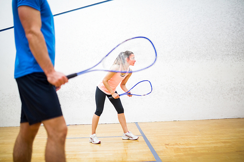 Woman about to serve the ball in the squash court