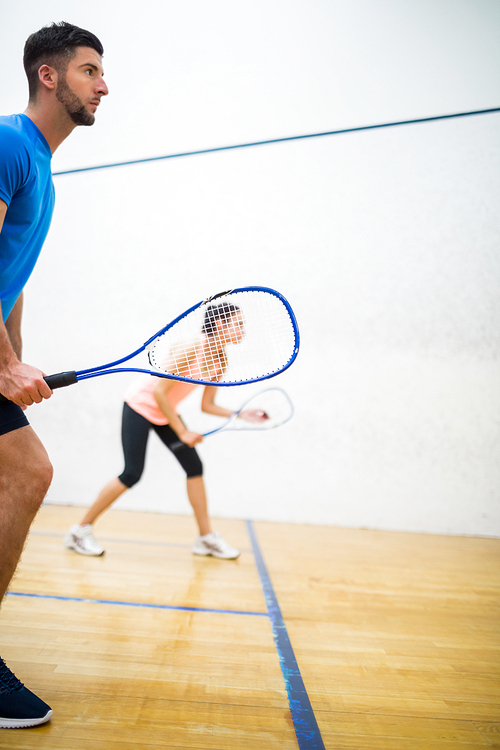 Woman about to serve the ball in the squash court