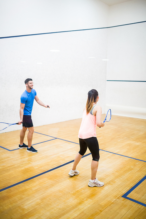 Couple playing a game of squash  in the squash court