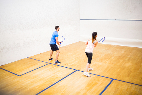 Couple playing a game of squash in the squash court