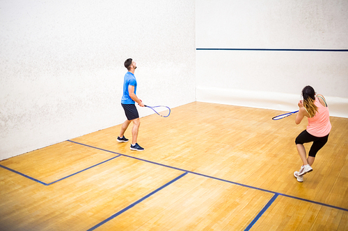 Couple playing a game of squash in the squash court