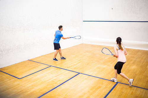 Couple playing a game of squash in the squash court