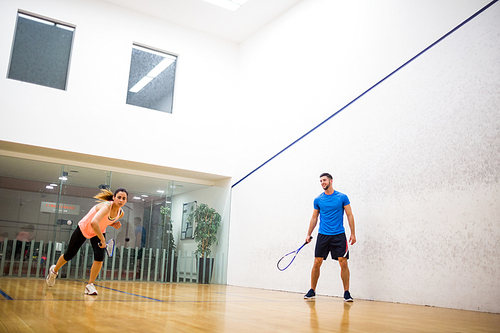 Couple playing a game of squash in the squash court