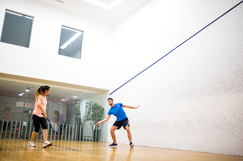 Couple playing a game of squash in the squash court