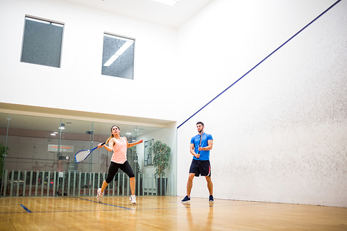 Couple playing a game of squash in the squash court