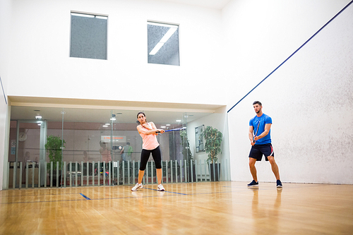 Couple playing a game of squash in the squash court