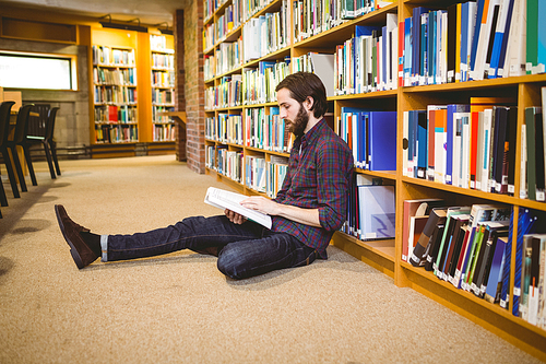 Student reading book in library on floor at the university