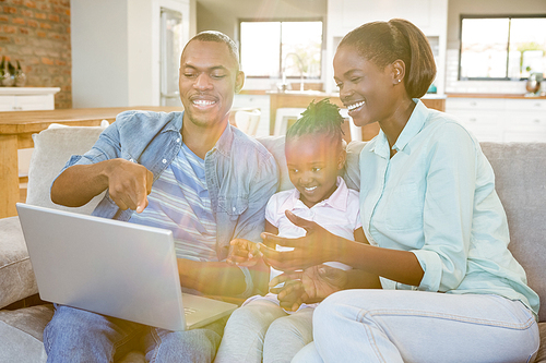Happy family using laptop on the couch in living room