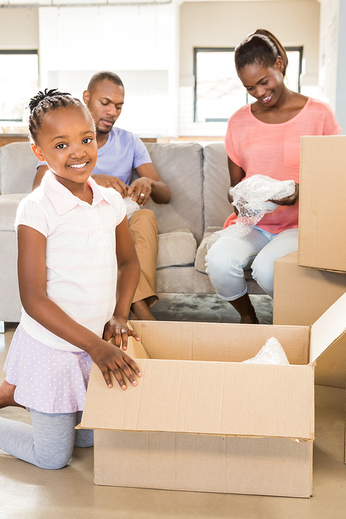 Family unwrapping things in new home in living room