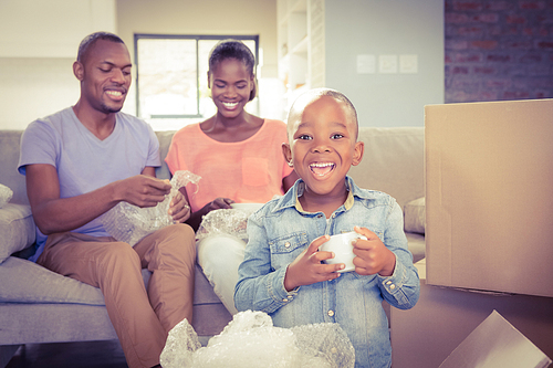Family unwrapping things in new home in living room