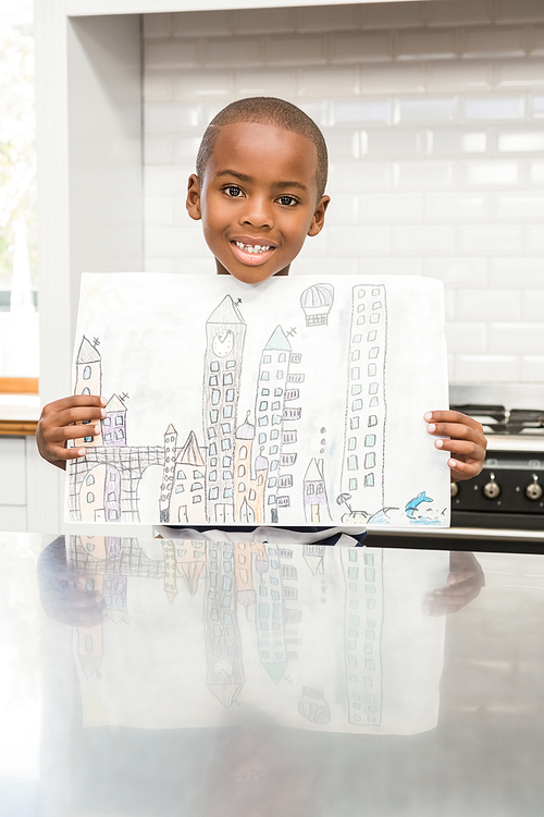 Smiling boy showing his drawing in the kitchen