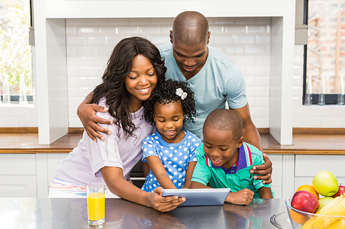 Happy family using tablet in the kitchen