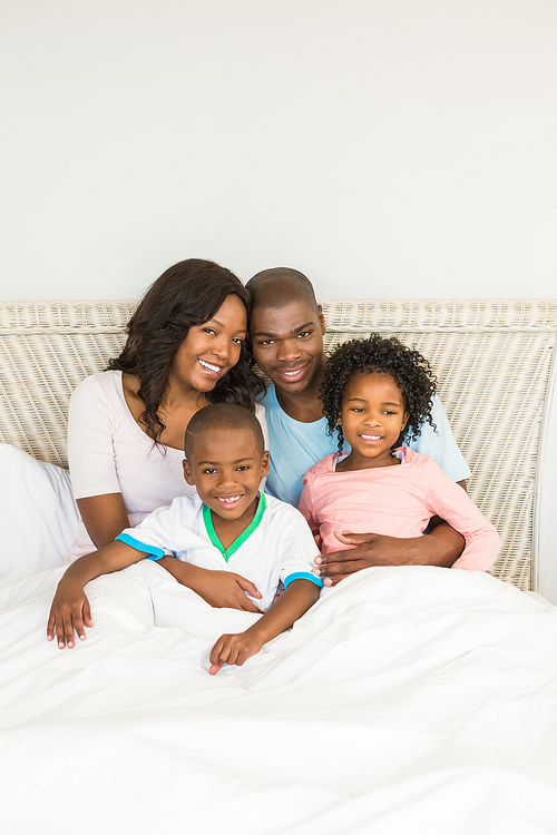 Happy family lying on bed at home