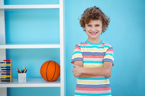 Smiling boy standing beside some toys in a room