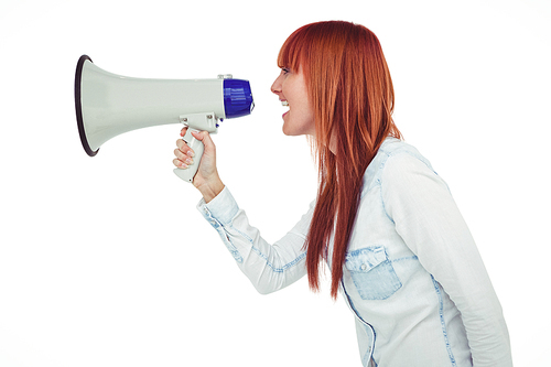 Side view of a hipster woman shooting through megaphone against white background