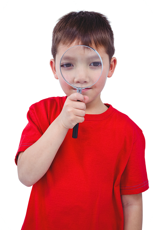 Standing boy using magnifying glass on white screen
